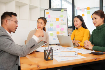 Group of Asian businessmen are sitting in a meeting, talking, exchanging knowledge. Presentation about office work