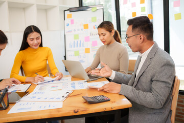 Group of Asian businessmen are sitting in a meeting, talking, exchanging knowledge. Presentation about office work