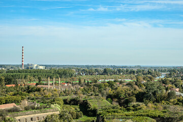 Fototapeta premium Agricultural fields with young green shoots of grain crops and plowed field without sowing. With trees in the background on the hills. Fallow concept. Alternation.