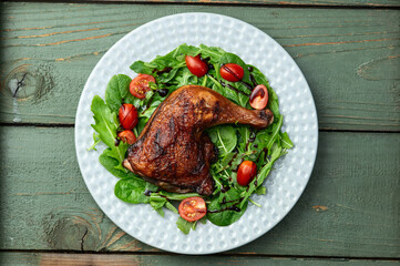 Grilled chicken legs with tomatoes and salad . Top view