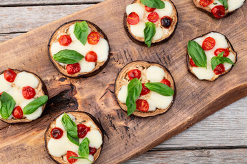 Italian mini pizza . Aubergine (eggplant ) with mozzarella cheese and basil . On rustic background