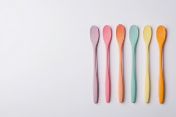 Colorful kitchen utensils arranged on a white background