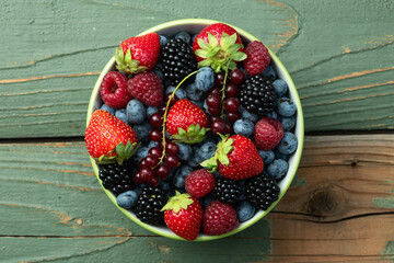 Mix of ripe colorful berries in bowl photography . Blueberry , strawberry , raspberry , blackberry and red currant . Top view