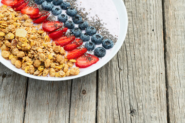Healthy breakfast . Yogurt with berries ( strawberry , raspberry , blueberry , blackberry ) , granola and chia seeds . Top view