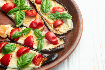 Italian mini pizza . Aubergine (eggplant ) with mozzarella cheese and basil . On rustic background