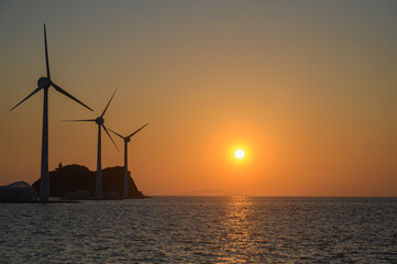on the beach with a wind turbine and an island in the background taken at the tando island port of Korea.