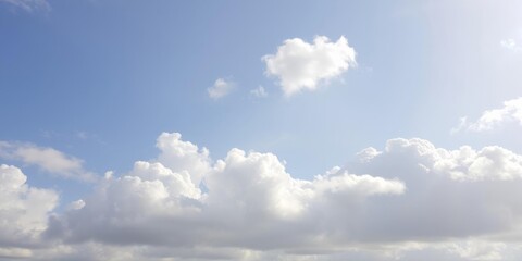 Obraz premium Fluffy white clouds floating in a clear blue sky on a sunny day, clouds, white