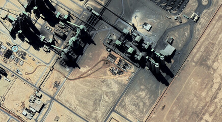 The landscape of a sandy desert and an oil plant in Qatar from a bird's eye view