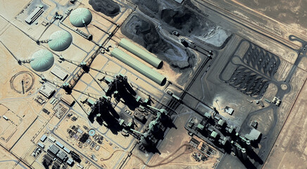 The landscape of a sandy desert and an oil plant in Qatar from a bird's eye view