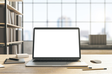 Front view on modern laptop blank white monitor with place for your text or logo on light wooden table with office tools on blurred window with city view background. 3D rendering, mock up