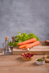 Fresh vegetables, herbs and cereals lie on a wooden countertop in the kitchen