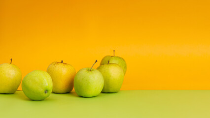 Green apples on yellow and green background
