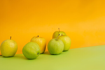 Green apples on yellow and green background