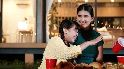 Family gather celebrate holiday. Focus on mother and daughter together have happy face, eat dinner party food. Outdoor activity for spending time with multigeneration cross generation gap. Divergence.