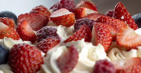 Delicious berry tart topped with whipped cream and fresh strawberries