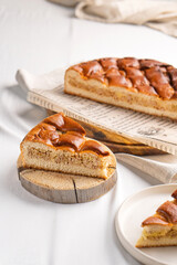 A piece of yeast pie with meat filling on a light background