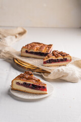 A piece of yeast pie with berry filling on a light background
