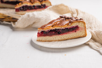 A piece of yeast pie with berry filling on a light background