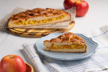 A piece of yeast pie with apple filling on a light background