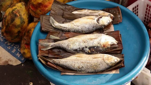 A close-up of salted sea fish sold on a wooden tray at a traditional market., indonesian food, indonesian fish