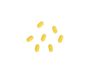 Long yellow pill on a white background
