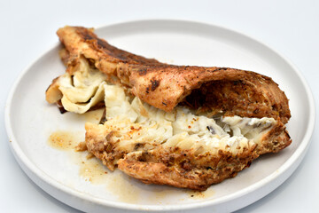 Fried fish, ready to eat, lies on a white plate.