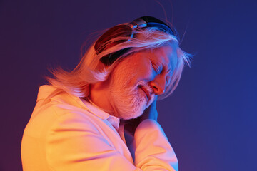 elderly man enjoying music, headphones, vibrant colors, emotional expression, blue and pink background, relaxed atmosphere, peaceful vibes, close up portrait, carefree moment