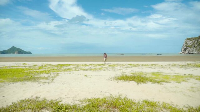 hippie rastaman dreads locks man run from the beach on a sunny day blue skies 