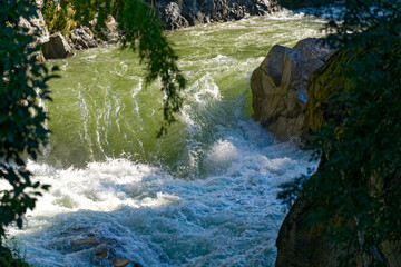 High angle view of Passer Passirio River at gorge of Italian City of Meran on a sunny summer day....