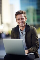Fototapeta premium A young businessman man with a smile on his face sits outdoors with a laptop against the background of skyscrapers. Generative AI.