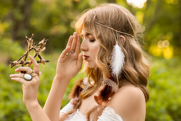 Portrait of young female shaman meditating in forest