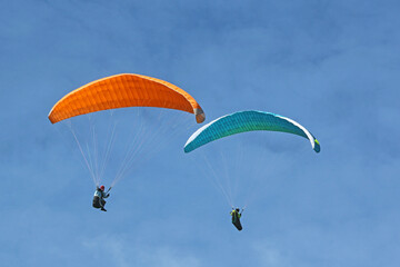 Paragliders flying in a blue sky	