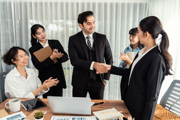Group of businesspeople shake hand after made successful business agreement meeting. Diverse race office worker celebrate after made progress on marketing planning in corporate office. Meticulous