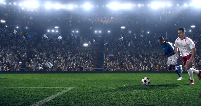 Football player is dribbling the ball down the field and kicks the ball towards the goal while other players trying to interfere. Professional stadium with animated crowd.