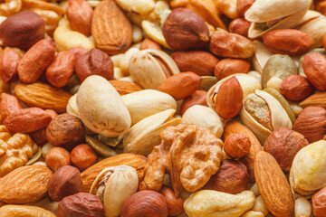 Variety of nuts and seeds closeup with selective focus - peeled walnut, hazelnuts, peeled peanut, pine nut kernels, almond seeds, cashew seeds, pistachio nuts in the shell, pumpkin seeds