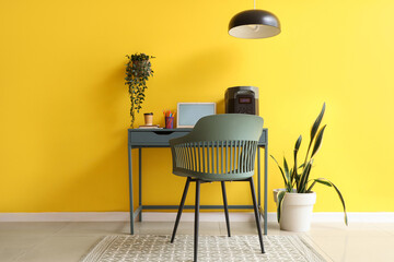 Interior of office with workplace, portable power station and plants
