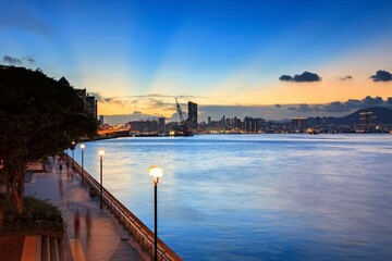 A Serene Evening Stroll Along the Harbor, with the City Skyline Glowing © Bossa Art