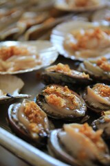 Grilled Shellfish with Garlic Topping on a Barbecue Grill