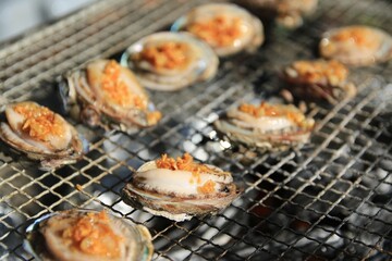 Grilled Shellfish with Garlic Topping on a Barbecue Grill