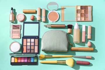 Composition with cosmetic bag, makeup products and accessories on green background