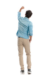 back view of casual man with arms up in triumph celebrating a win