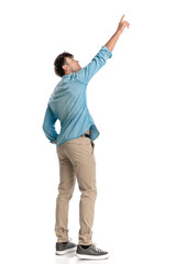 side view of casual man in denim shirt pointing finger to the sky