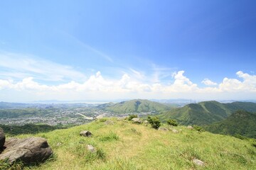 Scenic View of Rolling Hills and Distant Town Under Blue Sky, Tai Mo Shan, Hong Kong