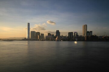 Obraz premium Sunset Over Hong Kong City Skyline with Reflective Water
