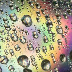 Close up of droplets and water drops on the surface of colorful CD