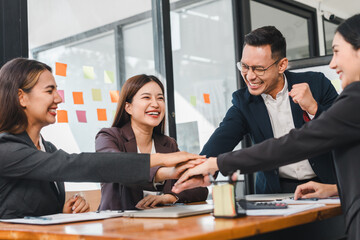Group of professionals celebrating success in modern office, showcasing teamwork and collaboration. Their joyful expressions reflect positive work culture