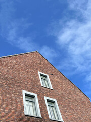 red brick building with white windows over sky