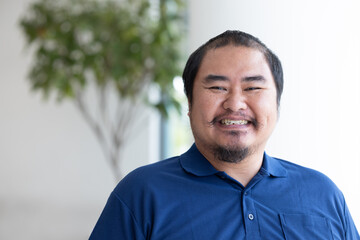 Obraz premium Happy smiling friendly middle aged Asian man, aged man with overweight and hair loss as signs of aging