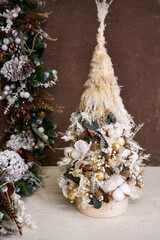 handmade Christmas tree with beige decoration and dried flowers 