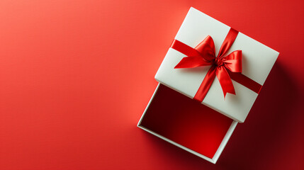 A white box with a red ribbon is open on a red background. The box is empty, but the red ribbon gives the impression of a gift. The red background adds a sense of warmth and excitement to the scene